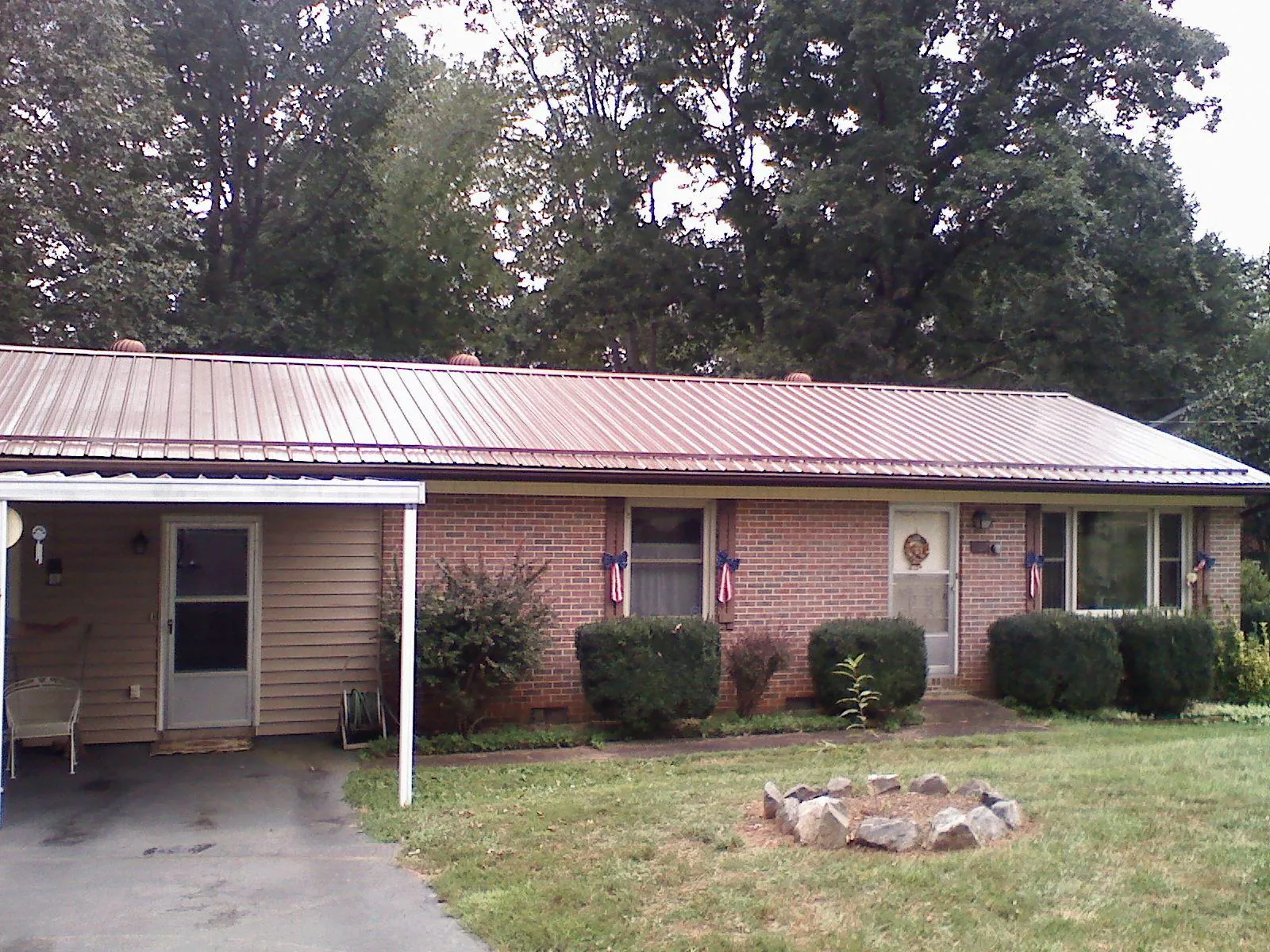 Bronze metal roof and carport on a brick ranch home — Roof Repair work by our crew in Gilmer